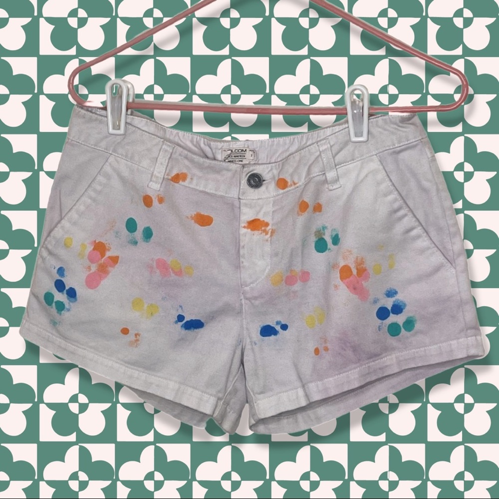 White Volcom shorts with ‘mostly’ symmetrical rainbow paint spots on back/front